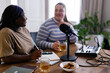 © Oleksii Syrotkin/Stocksy - Multiracial women drinking tea while creating content for podcast