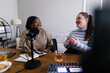 © Oleksii Syrotkin/Stocksy - Two plus size podcasters laughing while recording content at home