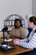 © Oleksii Syrotkin/Stocksy - Plus-size woman interviewing her friend for podcast at home office