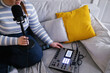 © Oleksii Syrotkin/Stocksy - Plus-size woman adjusting sound on audio mixer while recording podcast