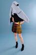 © Ulas&Merve/Stocksy - Creative Fashion Concept with Plaid Skirt and Blue Coat