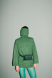 © Ulas&Merve/Stocksy - Fashionable Individual Wearing Green Knitted Sweater and Belt Ba
