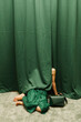 © Ulas&Merve/Stocksy - Person Hiding Behind Green Curtain with Handbag