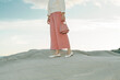 © Ulas&Merve/Stocksy - Woman in Pink Pants and White Shoes Holding Pink Handbag Outdoor