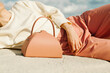 © Ulas&Merve/Stocksy - Closeup of Stylish Leather Handbag Next to Person Relaxing Outdo