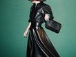 © Ulas&Merve/Stocksy - Fashionable Woman in Black Leather Dress Holding a Stylish Handb