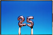 © Juan Moyano/Stocksy - holding number-shaped balloons forming the number 25, 35mm