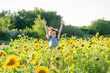 © Olena Smyrnova/Stocksy - Happy child jumping in a field with sunflowers