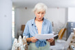 © JackF - Stressed mature woman homeowner examining room under reconstruction, having problems with documents of space planning