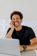 © BONNINSTUDIO/Stocksy - Professional smiling while working on laptop at desk