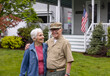 © Raymond Forbes LLC/Stocksy - Senior Citizen  Veteran Portrait front of home  hug wife
