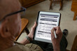 © Raymond Forbes LLC/Stocksy - Senior on tablet computer apply Veteran Medical benefits form