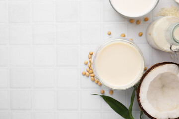 Sticker - Different types of vegan milk and ingredients on white tiled table, flat lay. Space for text