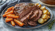 © Daniel L - A pot roast with cooked carrots and potatoes on a dining room table. A plate of comfort food.