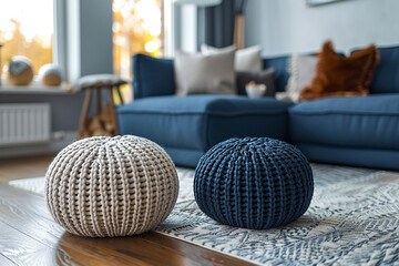 Two knitted poufs sit near a dark blue corner sofa, creating a modern Scandinavian home interior design in a cozy living room 