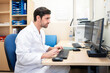 © Santi Nuñez/Stocksy - Doctor working on computer in medical office