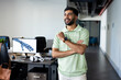 © Wavebreak Media - Smiling Indian man in office with robotic arm on computer screen in background