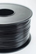 © Emanuel - 3D printer plastic filament. Spool of black thermoplastic wire for 3D printing, close up isolated on white background
