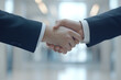 © Jiranun - Business handshake in a modern office, clean and professional.