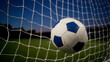 © ontsunan - A soccer ball hitting the net in a stadium under evening sky. Sports and outdoor activity concept.