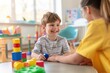 © sergiokat - Portrait of a child with autism working with a therapist during a session, both smiling and interacting positively. The therapy room is welcoming and filled with educational tools.