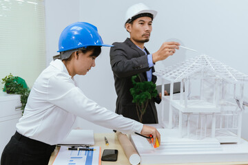 An office filled with a diverse team of professionals brainstorming and discussing computers and blueprints. An environment that showcases modern architecture and collaborative teamwork.