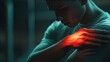 © Iswanto - A young man holds his injured shoulder, with a red glow highlighting the pain.
