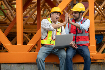 Wall Mural - Asia engineer man worker use tablet computer and hand touching with India engineer man with crane spare part background	