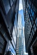 © joeycheung - A view of tall skyscrapers in Hong Kong, China. The buildings are made of glass and steel, and the sky is blue with white clouds.
