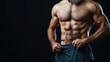 © altitudevisual - Close-up of a muscular man showing his well-defined abs and upper body muscles while holding his shorts. The image is set against a dark background.