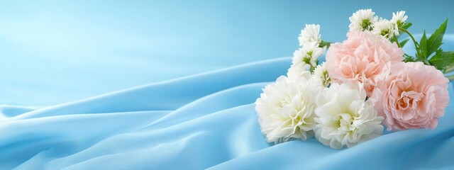  Three carnations - two pink, one white - arranged on a light blue silk backdrop A green, leafy twig emerges from the top