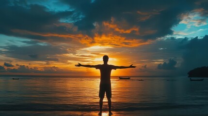 silhouette of man with outstretched arms at seaside sunrise freedom concept