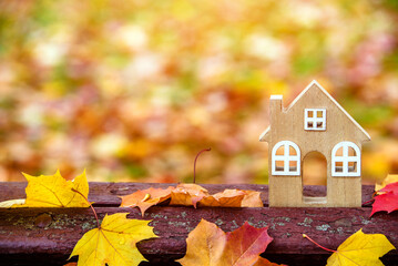 The symbol of the house stands among the fallen autumn leaves
