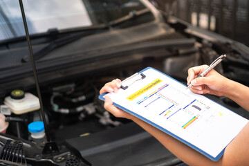 Wall Mural - close-up at a mechanic foreman's hand is checking on multi-point car service guideline checklist for
