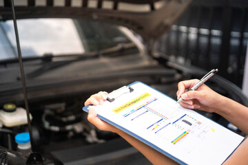 Wall Mural - close-up at a mechanic foreman's hand is checking on multi-point car service guideline checklist for