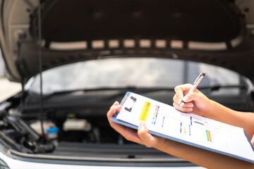 Wall Mural - close-up at a mechanic foreman's hand is checking on multi-point car service guideline checklist for