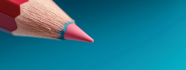 Wall Mural -  A close-up of a pink pencil against a blue sky backdrop displays a red tip instead