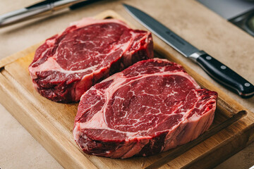 Fresh raw beef steaks on a wooden cutting board