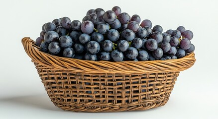 Wall Mural - A woven basket filled with fresh black grapes and green leaves on a neutral background