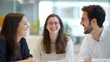 © North Media - Three colleagues are seated together, sharing a light-hearted moment during a meeting in a modern office. Positive atmosphere among the team members, collaborative spirit.