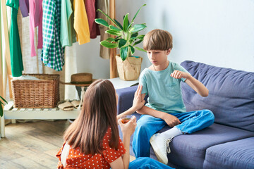 Wall Mural - Mother engages playfully with her hearing impaired son in a cozy living room.