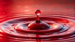 © Kukar Studio - Close-up of red liquid droplet on scarlet surface surrounded by smaller water droplets