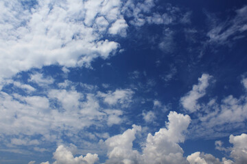 blue sky with clouds, clouds in the sky scattered in the dark blue sky bright white shiny clouds