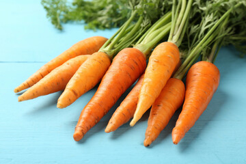 Poster - Tasty ripe juicy carrots on light blue wooden table, closeup