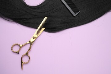 Wall Mural - Black hair strand, comb and professional scissors on violet background, top view. Space for text