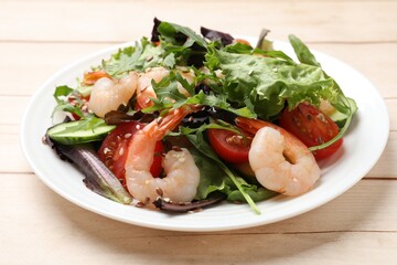 Delicious shrimp salad with vegetables on wooden table, closeup