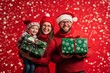 © Miss V - happy couple with child, in Christmas clothes, holding  wrapped boxes with presents, is smiling and posing against red background. Season greetings concept