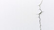© Thamrong - A close-up shot of a white wall, with a single, thin crack running vertically down its length. The crack, dark and jagged, stretches from the top to the bottom of the image, creating a striking