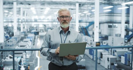 Aufkleber - Portrait of a Bearded Electronics Manufacture Engineer Smiling, Looking at Camera. Senior Man Using Laptop Computer for Online Research, Monitoring Artificial Intelligence Systems