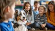 © พงศ์พล วันดี - Australian Shepherd dog with children in a classroom setting.